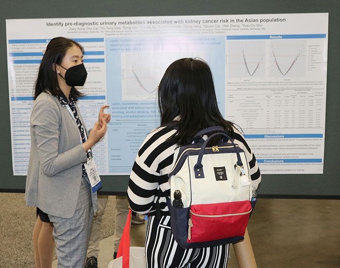 A poster presenter explains her research to another attendee.