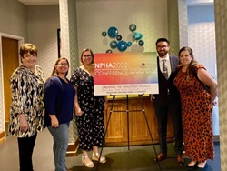 Members of the Nevada Public Health Association posing in front of a sign at their annual conference