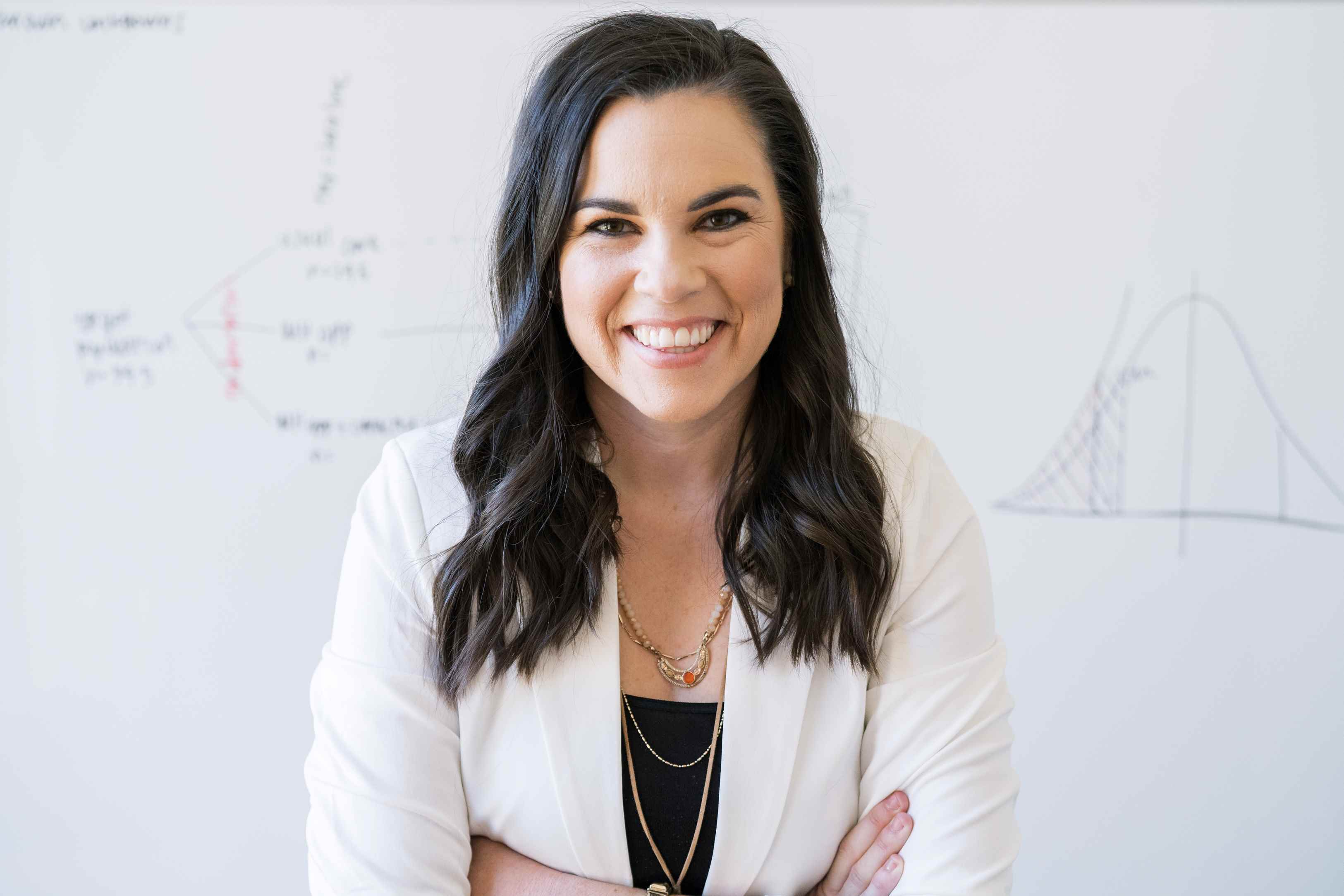 Photo of Katelyn Jetelina in front of whiteboard with charts