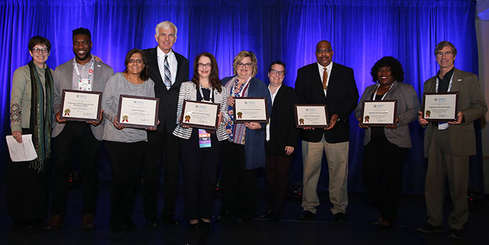 10 people displaying awards certificates