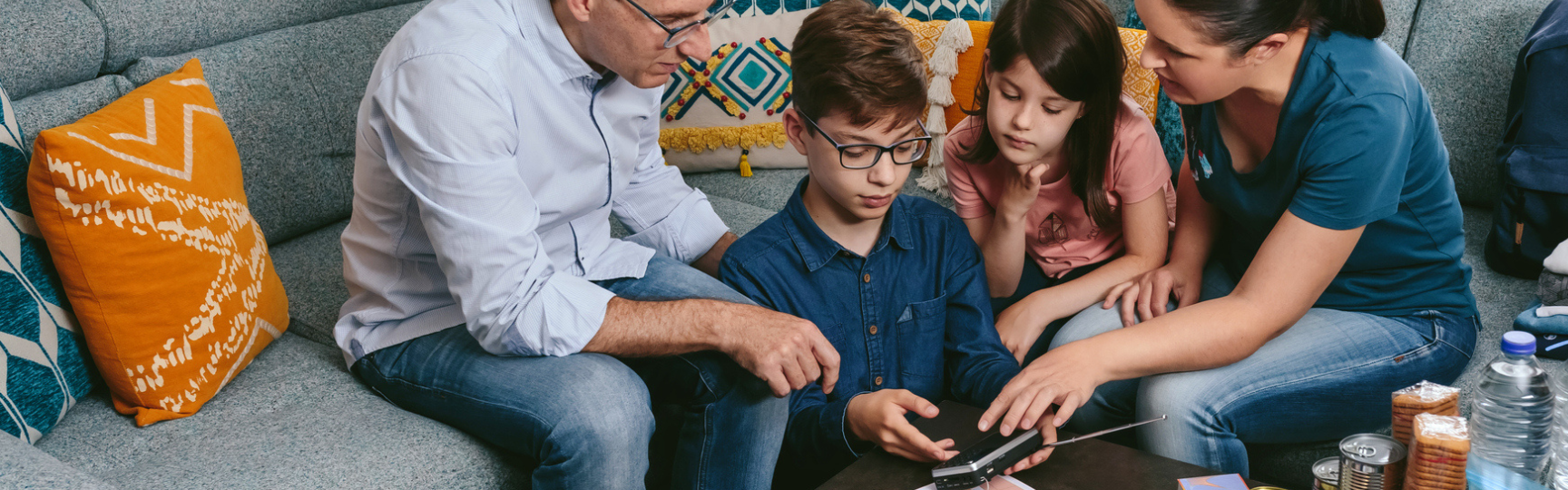 A family of four gathered around items on a table